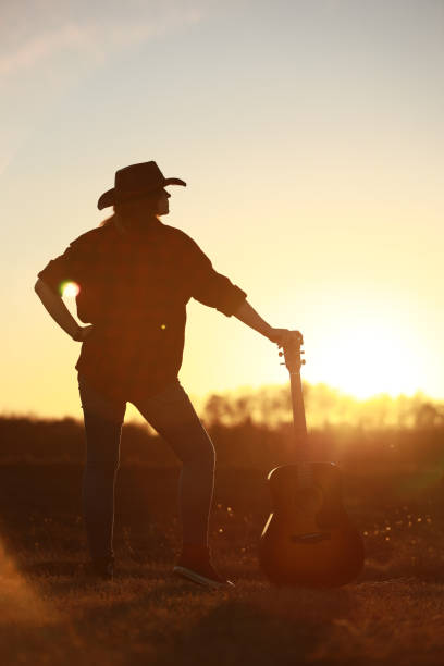 istock cowgirl with guitar at sunset 1387339961