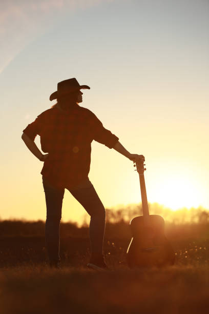 istock cowgirl with guitar at sunset 1387339962