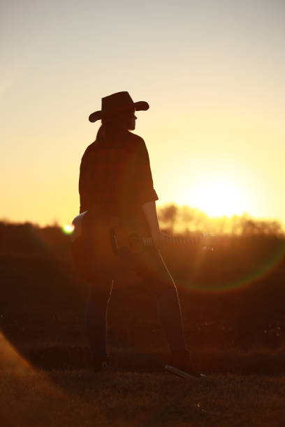 istock cowgirl with guitar at sunset 1387339965