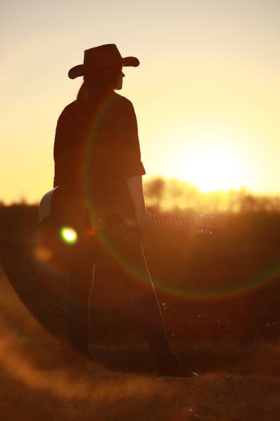 istock cowgirl with guitar at sunset 1387339970