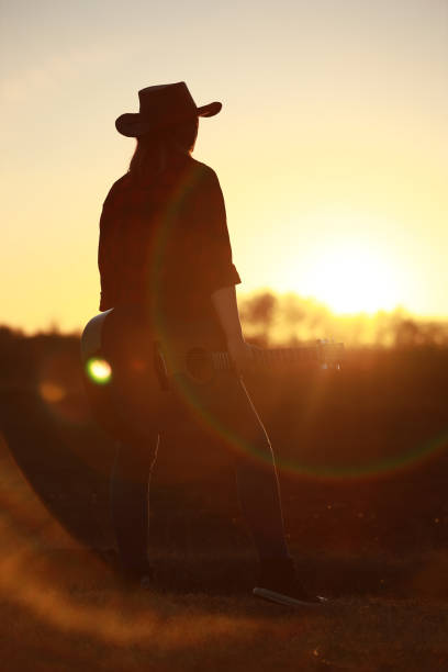 istock cowgirl with guitar at sunset 1387339975