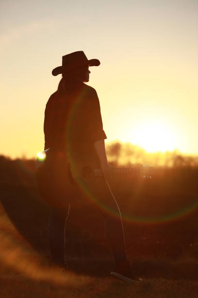 istock cowgirl with guitar at sunset 1387339976