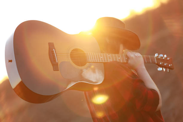 istock cowgirl with guitar at sunset 1387339983