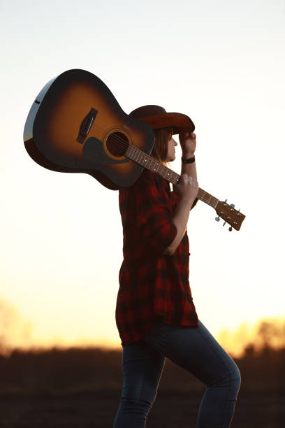 istock cowgirl with guitar at sunset 1387339991