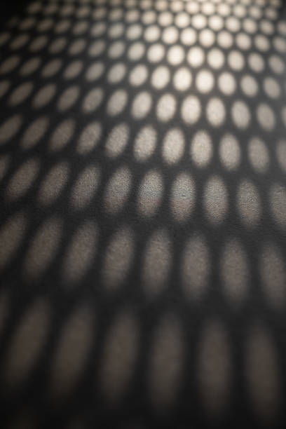 istock Beams of sunlight shining through perforated sheet metal 1387341946