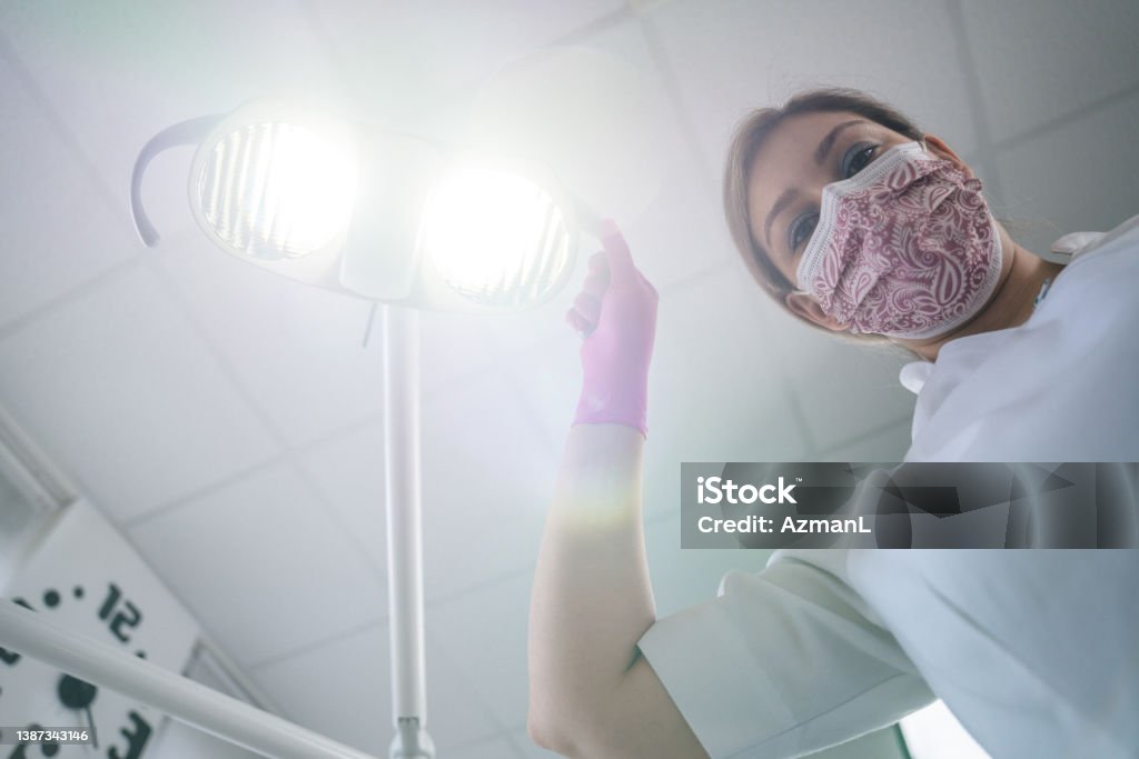 Professional Female Dentist During Her Work Close-up photo of a young Caucasian female dentist wearing protective gloves during her professional work. 25-29 Years Stock Photo