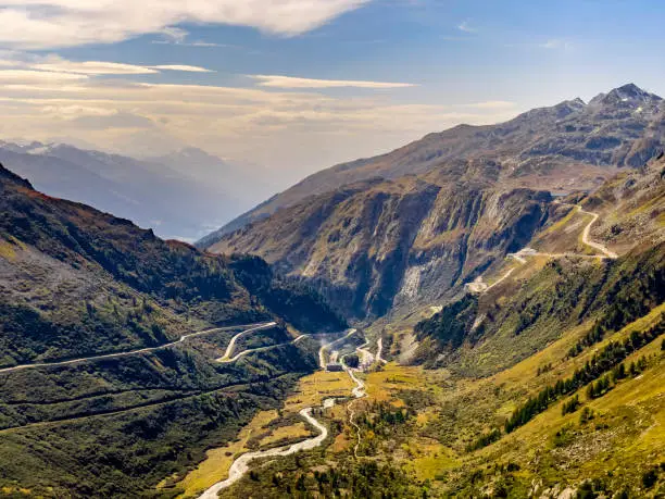 View of Swiss Alps mountain valley and Furka mountain pass with its curvy, winding roads