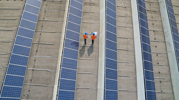 Engineers walking on rooftop Aerial view of engineers walking on rooftop of a solar power plant. two men same clothes stock pictures, royalty-free photos & images