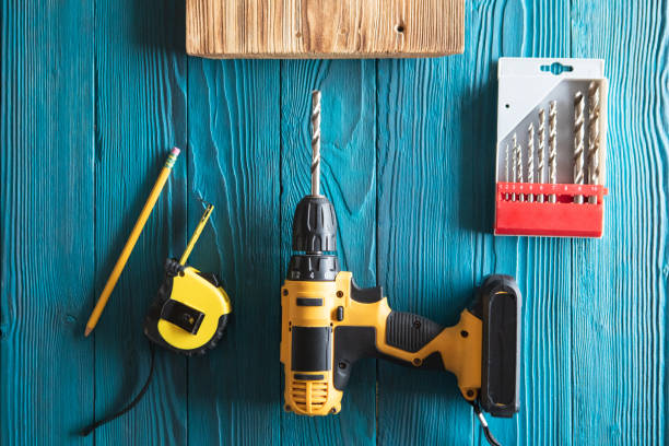 istock Handyman in blue uniform works with electricity automatic screwdriver. House renovation conception. 1387345464