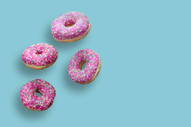istock Creative food concept: levitating dounuts isolated on blue background. 1387345517