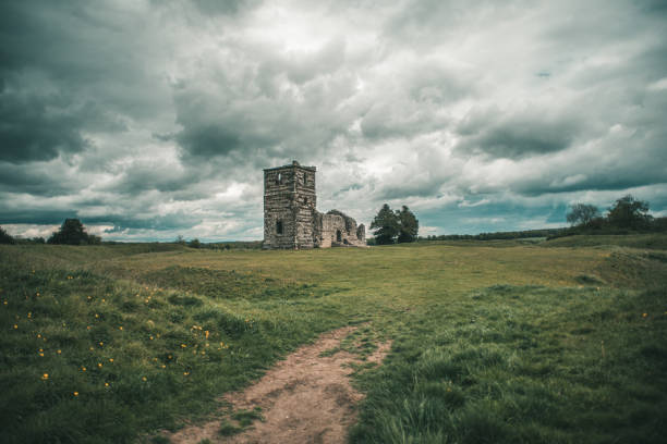 Knowlton Church stands isolated beneath cloudy skies in southern England.