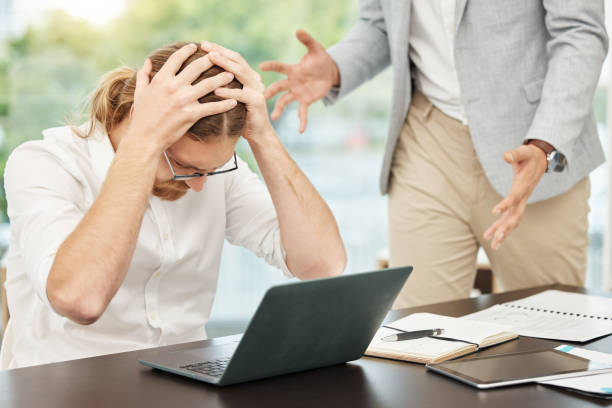 オフィスで同僚と口論をしている最中にストレスを感じている若いビジネスマンのショット - manager anger table furious ストックフォトと画像