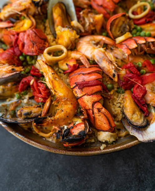 deliziosa paella di pesce - seafood lobster paella prepared shellfish foto e immagini stock