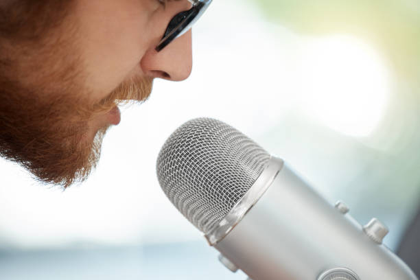 istock Closeup shot of a businessman using a microphone during a broadcast in an office 1387349889