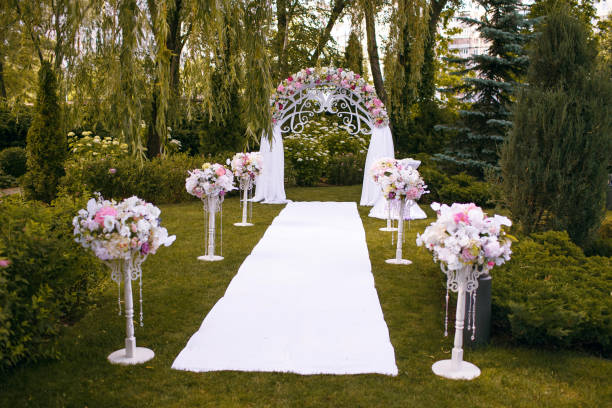 istock a beautiful wedding arch decorated with flowers in the forest, a white path is ready for the newlyweds 1387349917