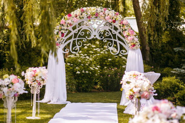 istock a beautiful wedding arch decorated with flowers in the forest, a white path is ready for the newlyweds 1387349918