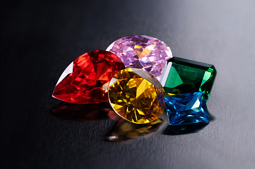 Three faceted red rhodolite garnets isolated on white background.