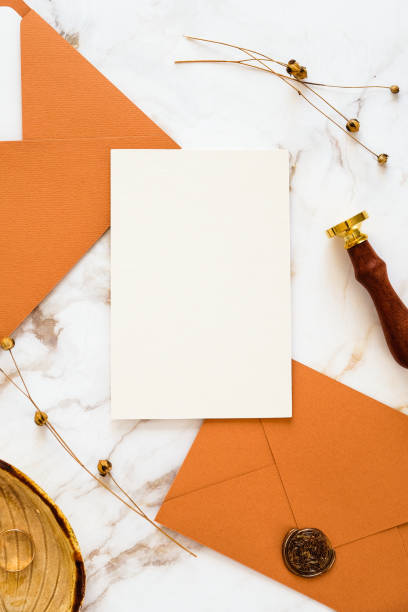 istock Wedding invitation card template with bronze envelopes and wax seal stamp on marble table top view. 1387352202