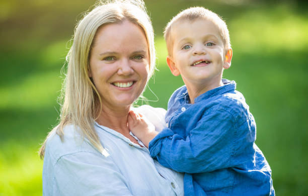 Portrait of Mother and son outdoors in the sunshine. Portrait of Mother and son outdoors in the sunshine. Both are happy and smiling. cleft lip stock pictures, royalty-free photos & images