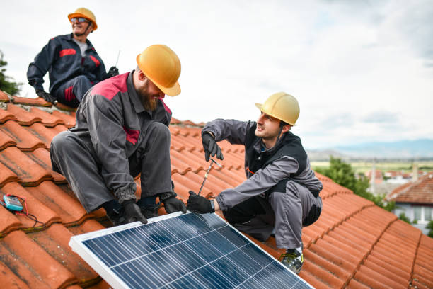 istock Male Workers Checking If Solar Panel Is Properly Tightened On House Roof While Dragging It 1387354407