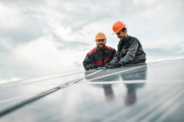 istock Two Happy Male Workers Writing Down Measurements Of Solar Panel 1387355520