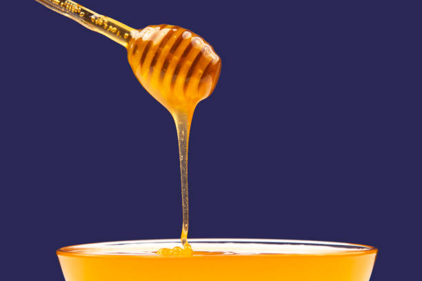 istock fresh fragrant honey drips from a spoon into a plate on a colored background. organic vitamin nutrition. dessert food 1387357450