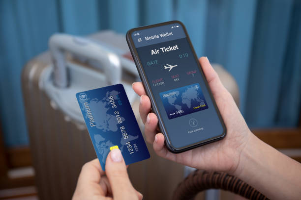 manos femeninas sujetan el teléfono de la aplicación de billetes de avión de las aerolíneas tarjeta de crédito - hacer una reserva fotografías e imágenes de stock