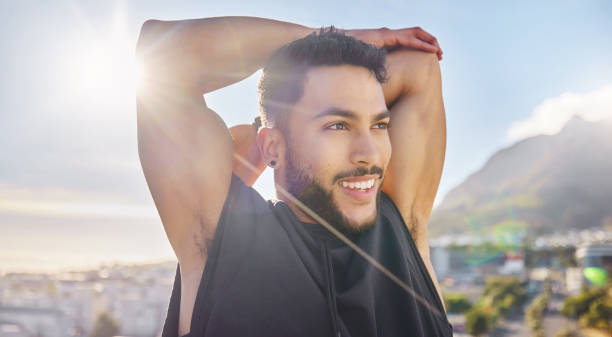 istock Shot of a sporty young man stretching while on a rooftop 1387358733