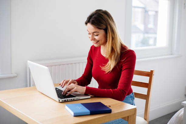 istock Woman using laptop at home 1387359381