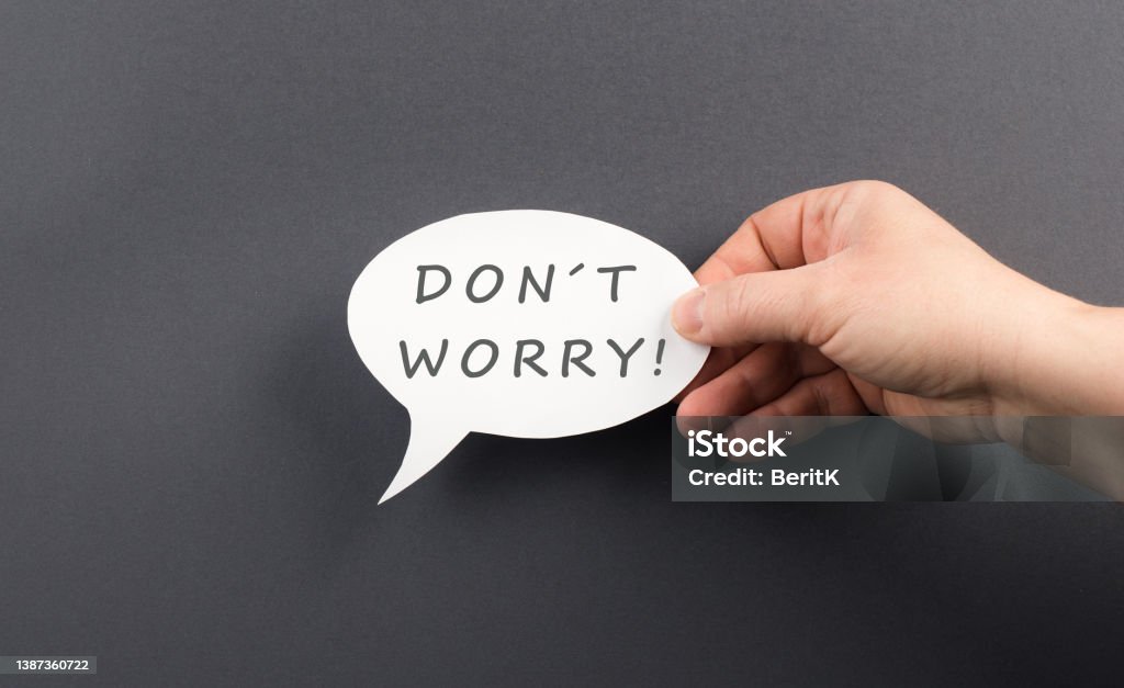 Don´t worry is standing on a speech bubble, hand holds the message, positive message, no problems Letter - Document Stock Photo