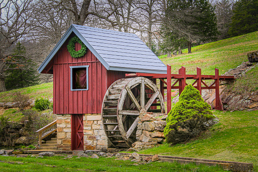 a vintage hillside waterwheel turbine red wooden hunt mountain stream raised water shed