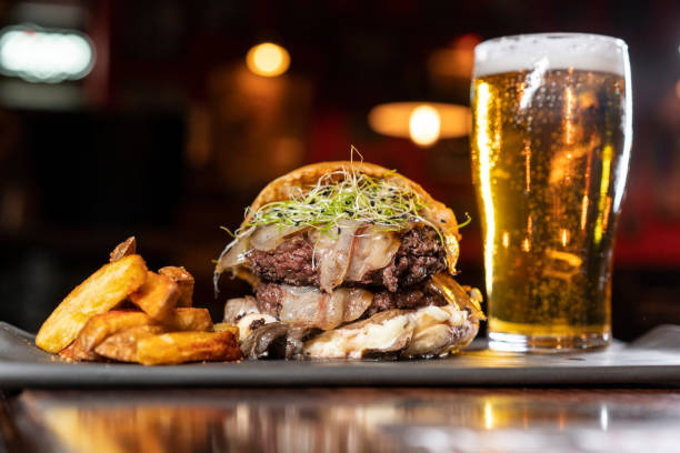 Bacon and cheese tasty burger meal with fries and beer Bacon and cheese tasty burger meal with fries and beer in a restaurant spanish hamburger stock pictures, royalty-free photos & images
