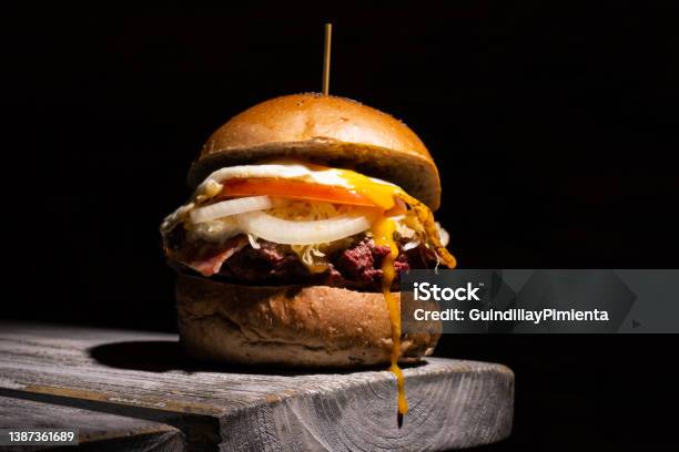 Home Made Tasty Burger On Wooden Table And Black Background Stock Photo - Download Image Now