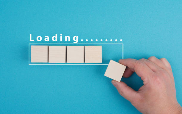 istock The word loading is standing over the progress bar, hand puts last cube to the row, business, education and marketing concept download a new program 1387361770