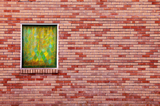 a red brick church building wall green stained class square window cross retro vintage architectural design