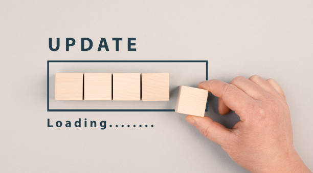 istock The words update in progress are standing beside the loading bar, hand puts last cube to the upload, petrol colored background 1387362199