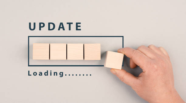 The words update in progress are standing beside the loading bar, hand puts last cube to the upload, petrol colored background stock photo