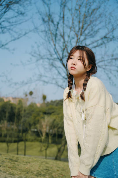 istock A beautiful asian girl playing happily under a tree on a sunny day 1387362226