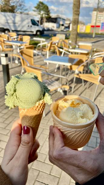 istock Two people holding a cone of ice cream 1387366877