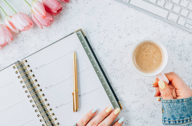 istock Feminine workspace for online work with keyboard, tulip flowers, office supply and coffee on a white background. Distance study concept 1387368190