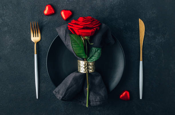 istock Festive table setting for Valentine's Day with cutlery, rose and chocolate hearts. Flat lay 1387368200