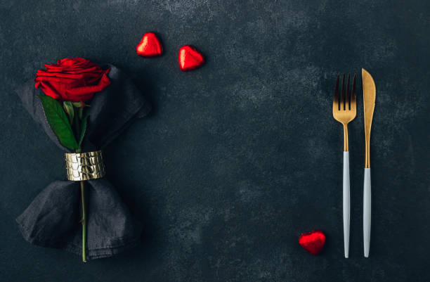 istock Festive table setting for Valentine's Day with cutlery, rose and chocolate hearts. Flat lay 1387368216