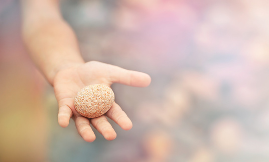 background with a round stone in a child's palm