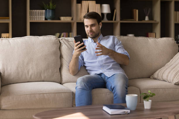 istock Happy relaxed young man holding video call. 1387372775