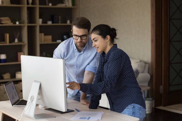 istock Concentrated smiling young multiracial employees cooperating in office. 1387372812