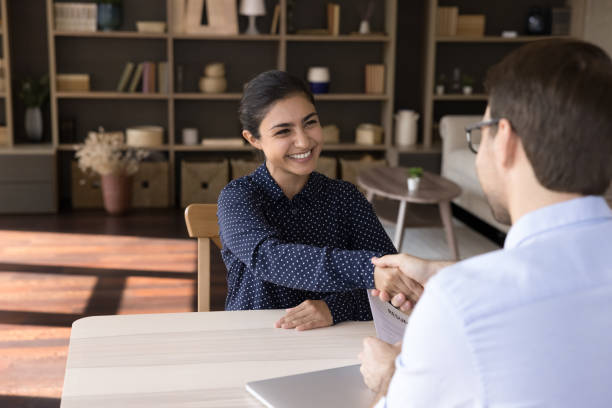 istock Smiling young Indian woman shaking hands with hr manager. 1387372815