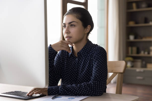 istock Concentrated thoughtful young Indian businesswoman working on computer. 1387372822