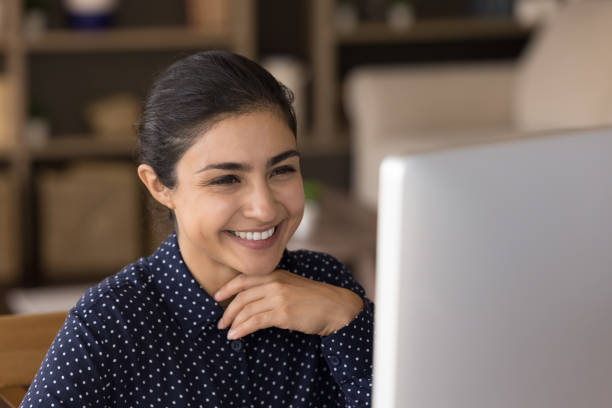 istock Smiling young Indian businesswoman working on computer in office. 1387372827