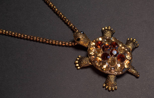 istock Golden turtle with red jewels on a dark background 1387372854