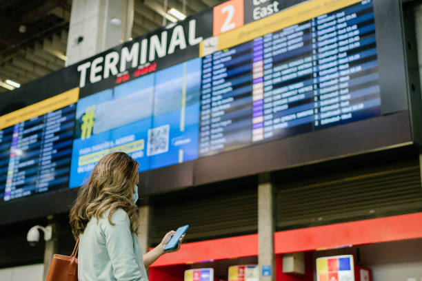 istock Mature woman checking her flight at airport front panel 1387379897
